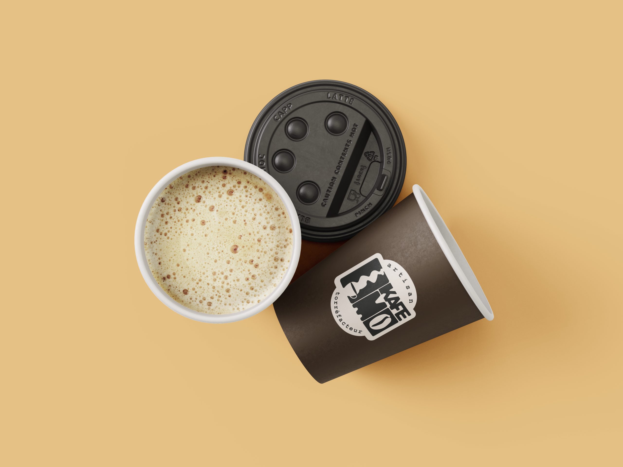 Kafémo café au lait dans gobelet papier noir avec logo, sur fond beige — coffee truck artisanal La Baule